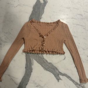 tan cropped shirt with braided pattern, ruffles at bottom of sleeves and shirt